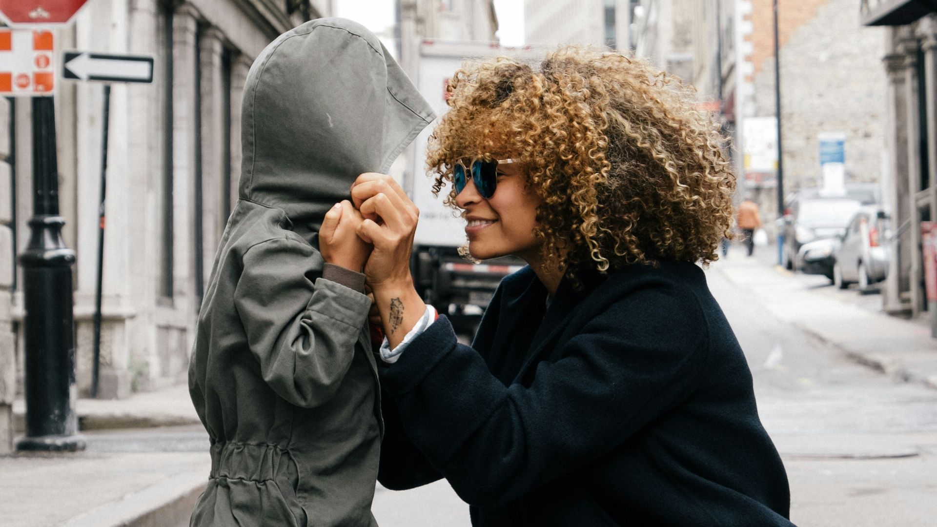 woman holding kid at the street