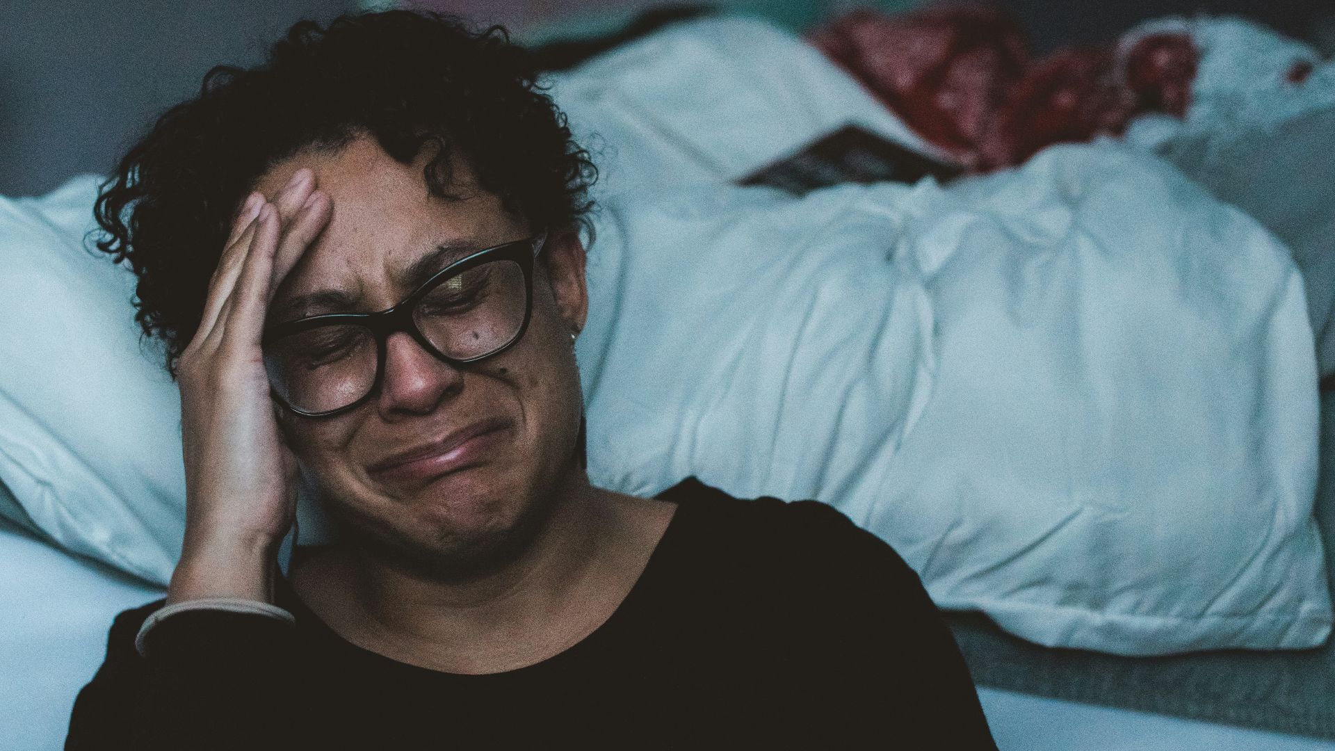 person crying beside bed