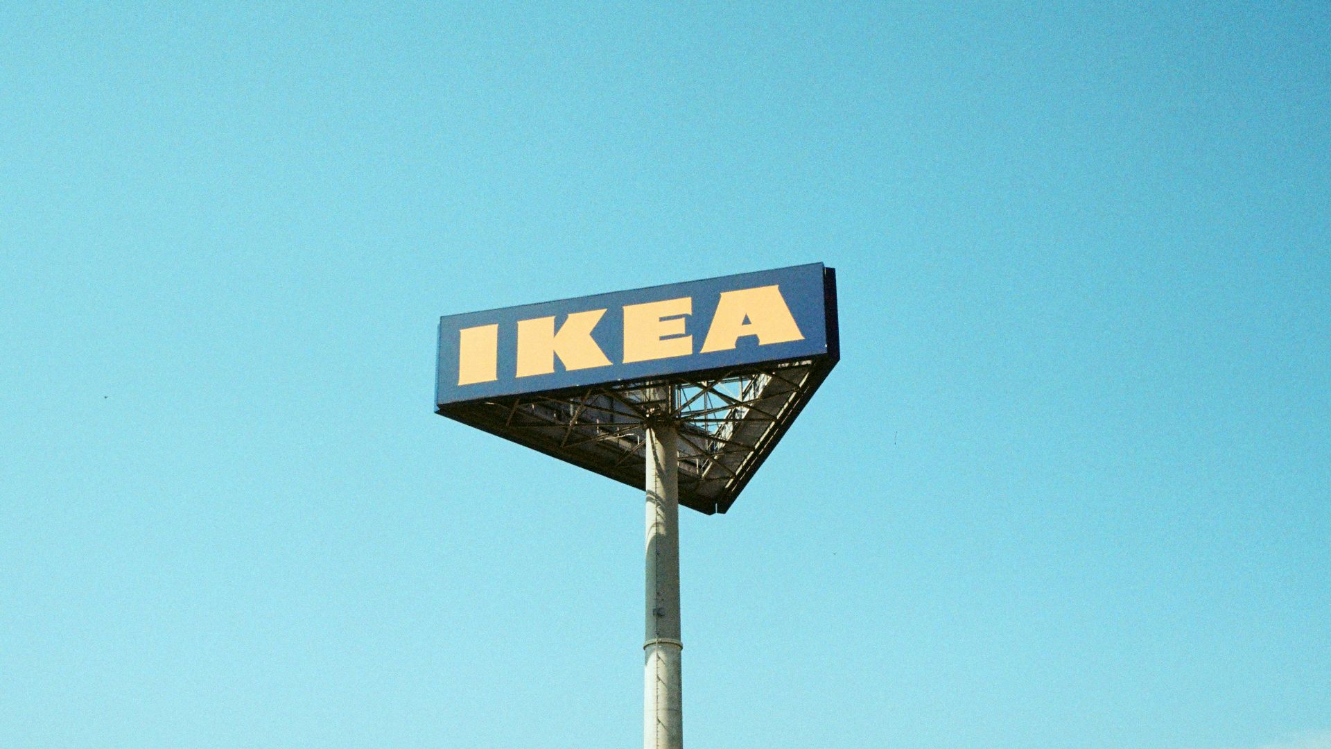 a ikea sign on a pole against a blue sky