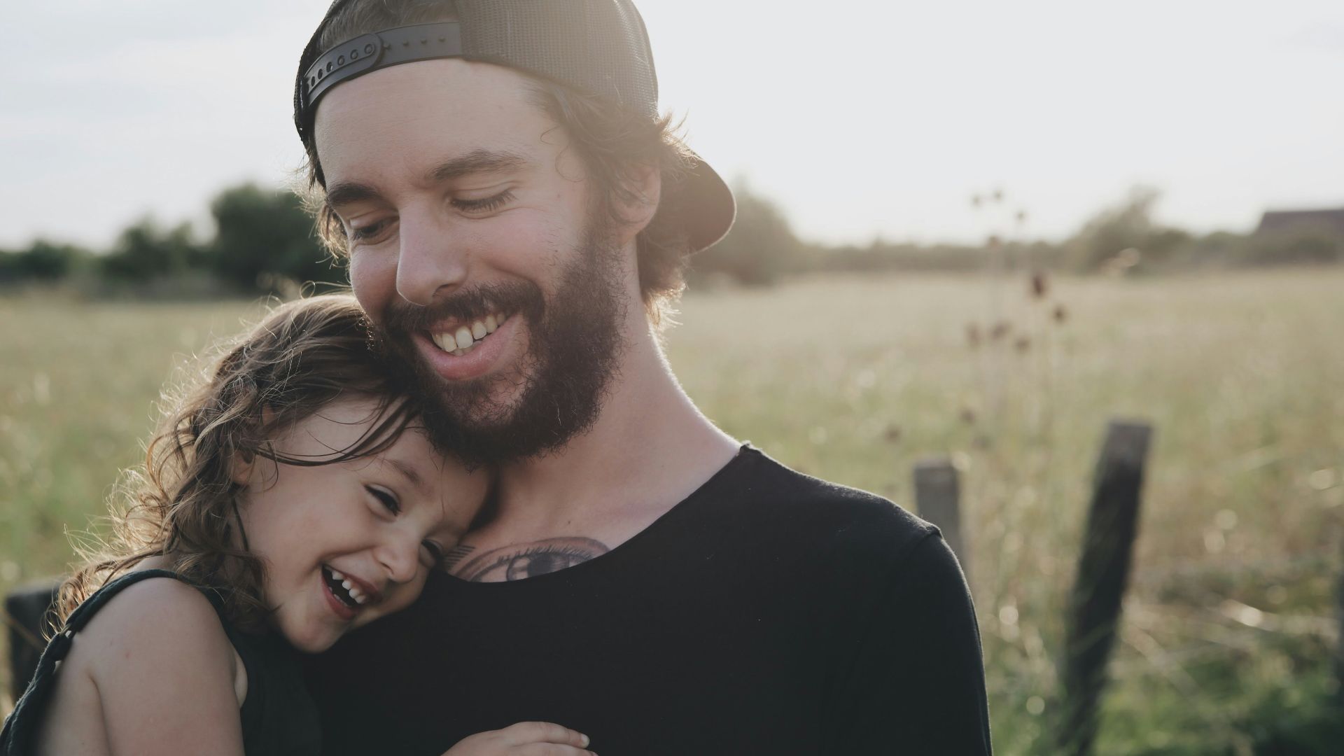 man carrying daughter in black sleeveless top