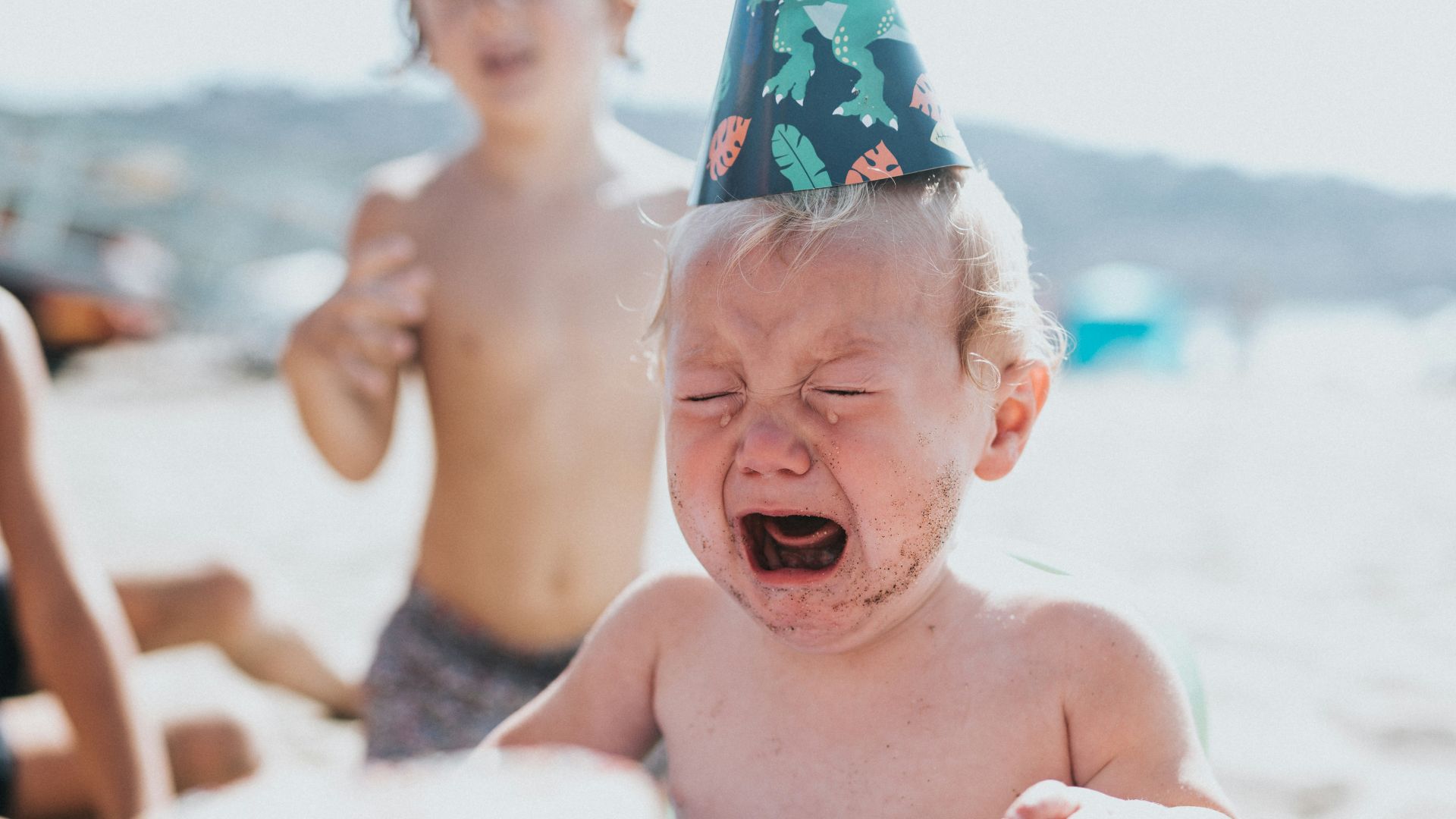 topless boy in blue and white floral shorts sitting on white and blue inflatable pool during