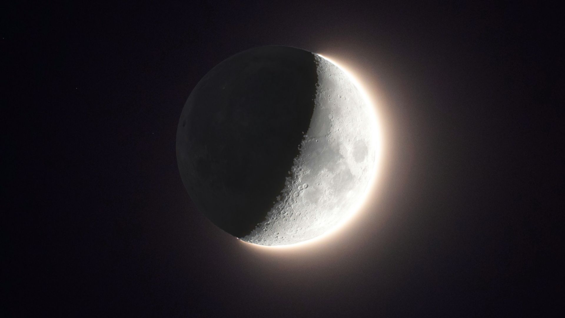 the moon is seen in front of a black background