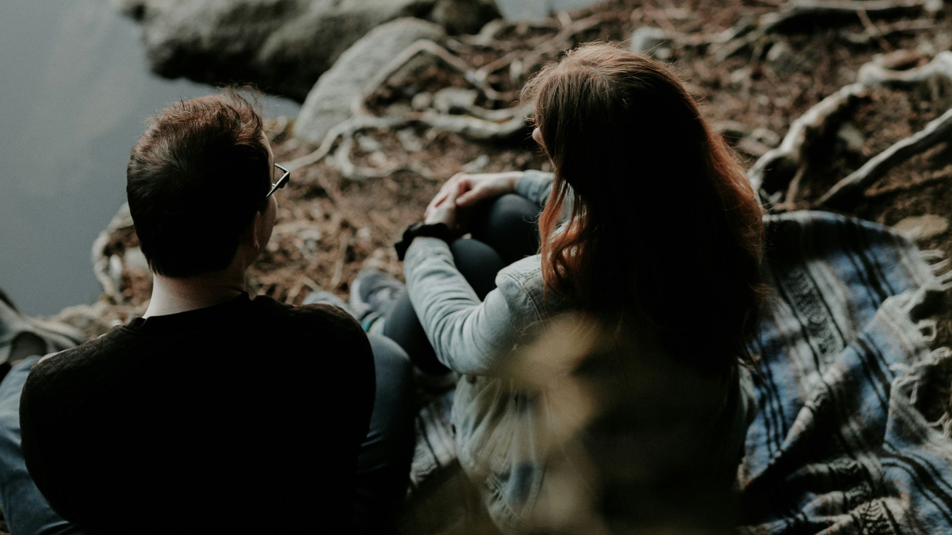 couple sitting near the body of water