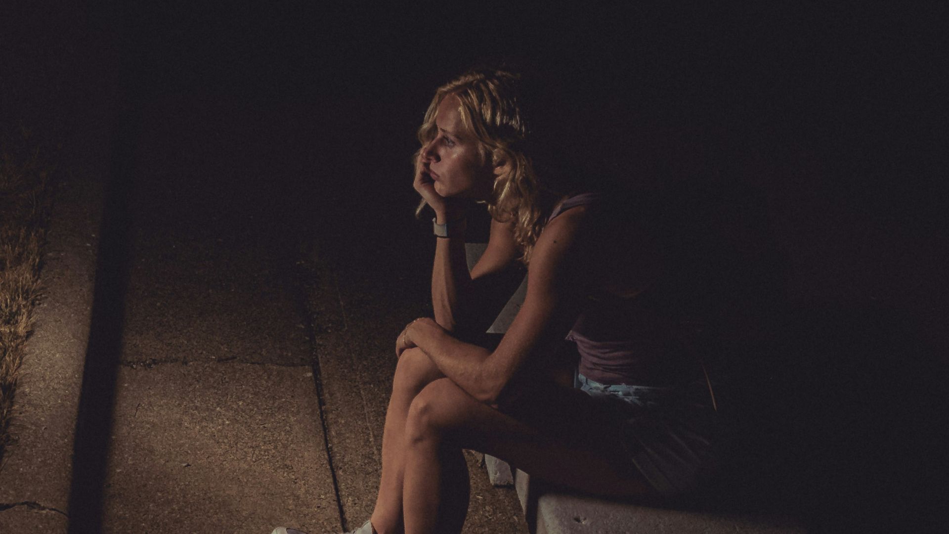 woman in black tank top sitting on concrete floor