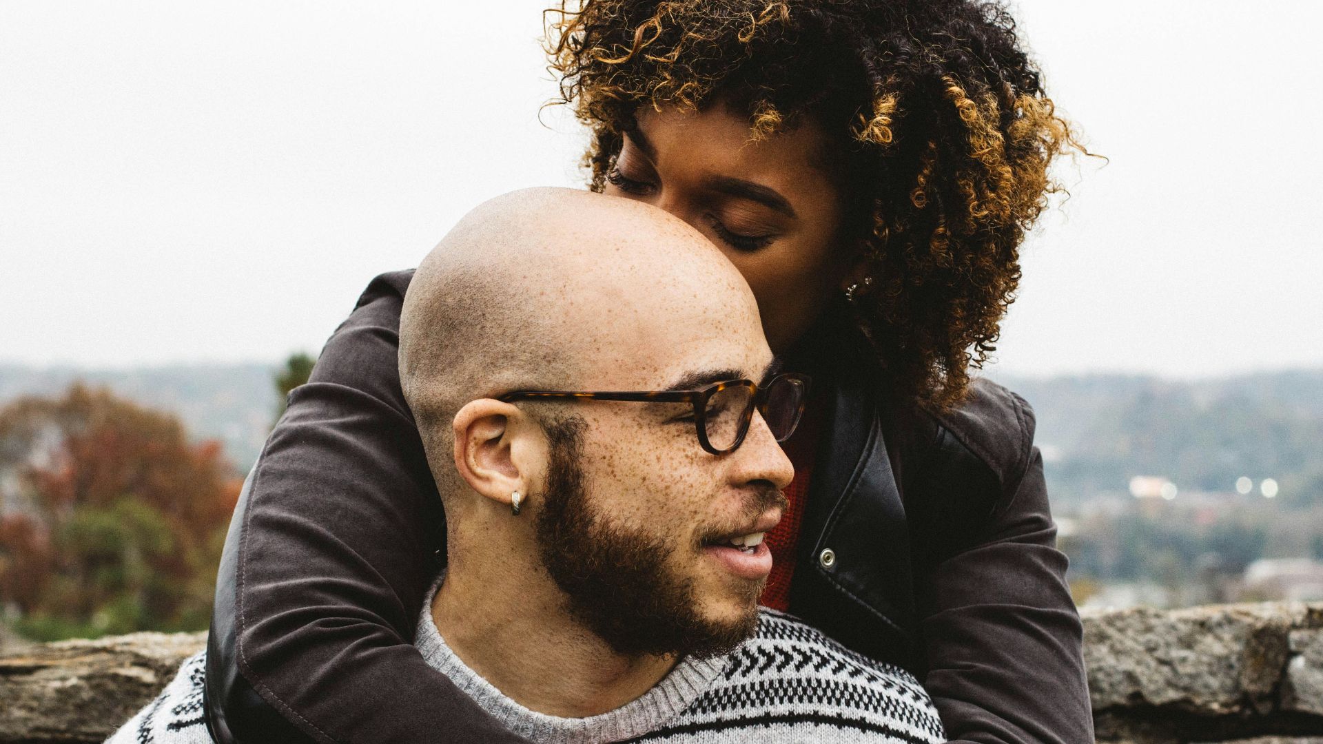 woman kissing man's head