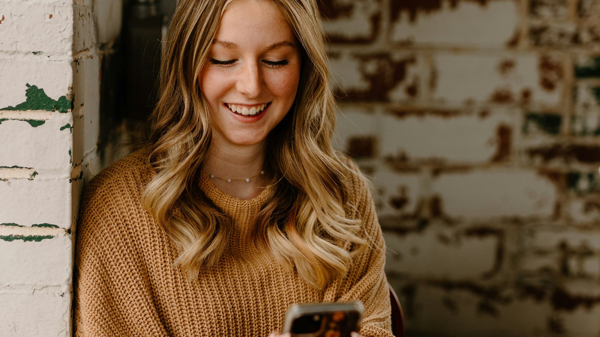 a woman sitting at a table looking at her cell phone
