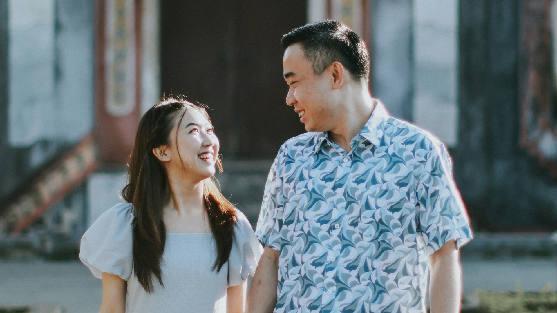 Couple holding hands in front of traditional building