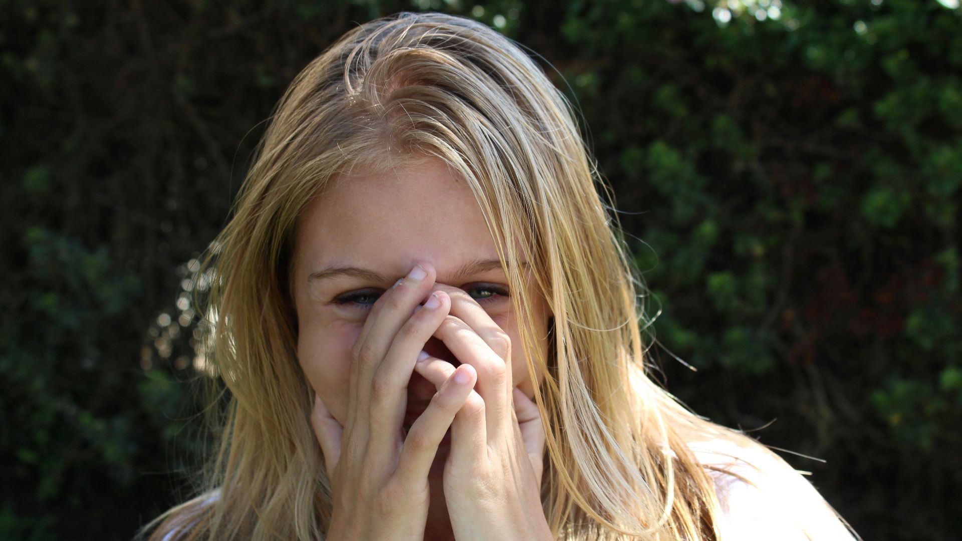 woman covering face with both hands