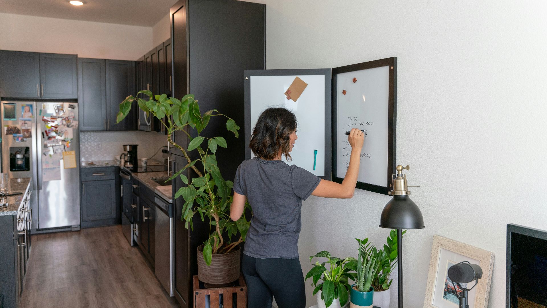 a woman standing in front of a refrigerator in a kitchen