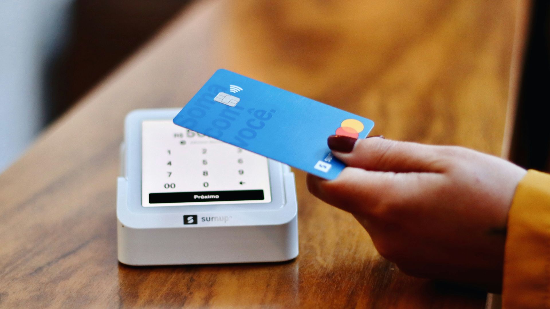 a person holding a credit card in front of a machine