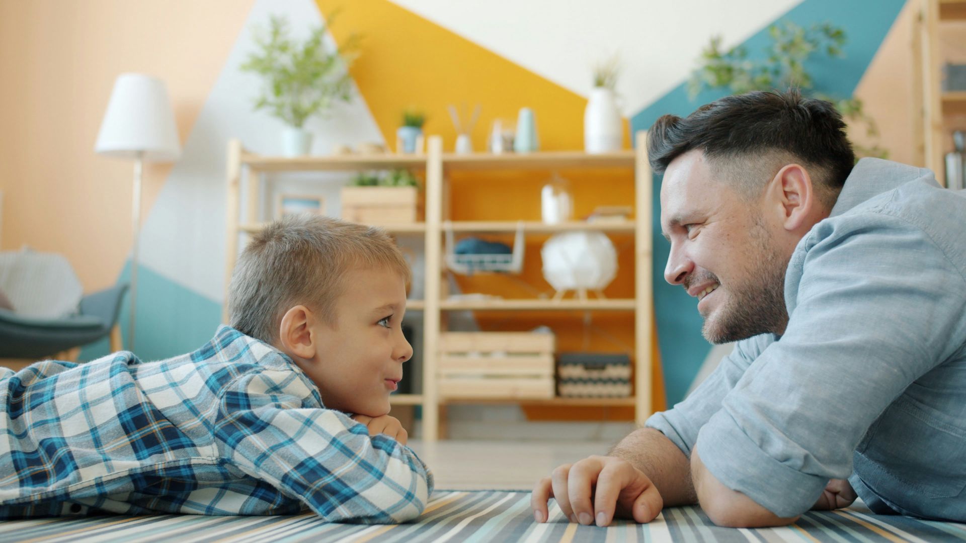 Father and son looking at each other on floor
