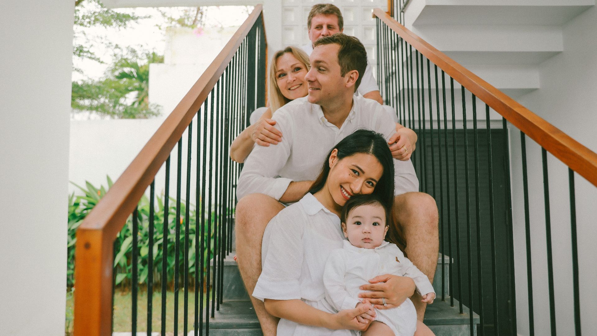 Family sitting on stairs, dressed in white