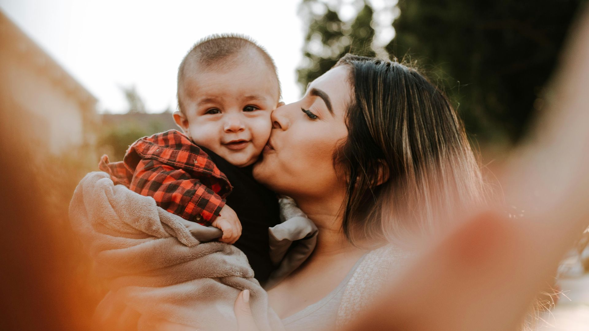 woman kiss a baby while taking picture