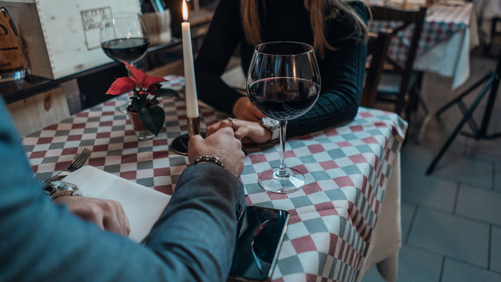 woman wearing black sweater holding hand with man wearing gray suit jacket