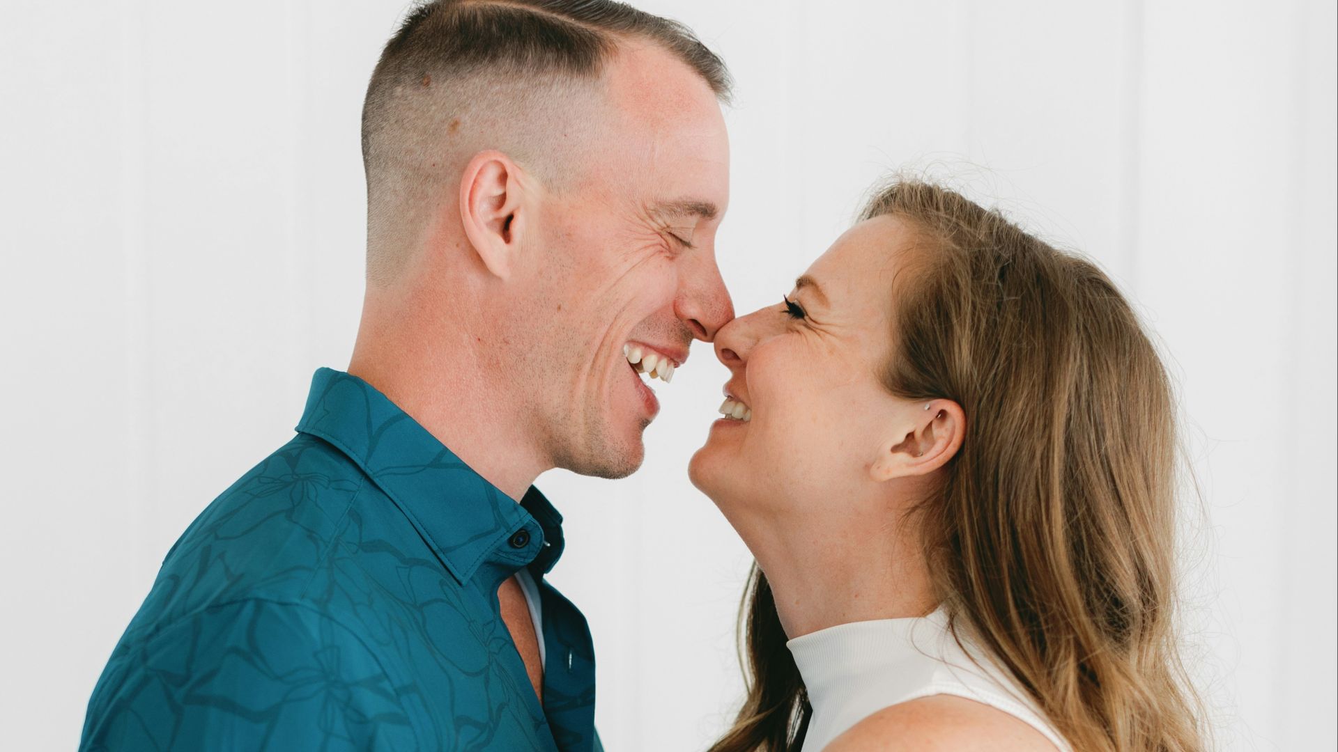 Happy couple laughing together, close to each other.