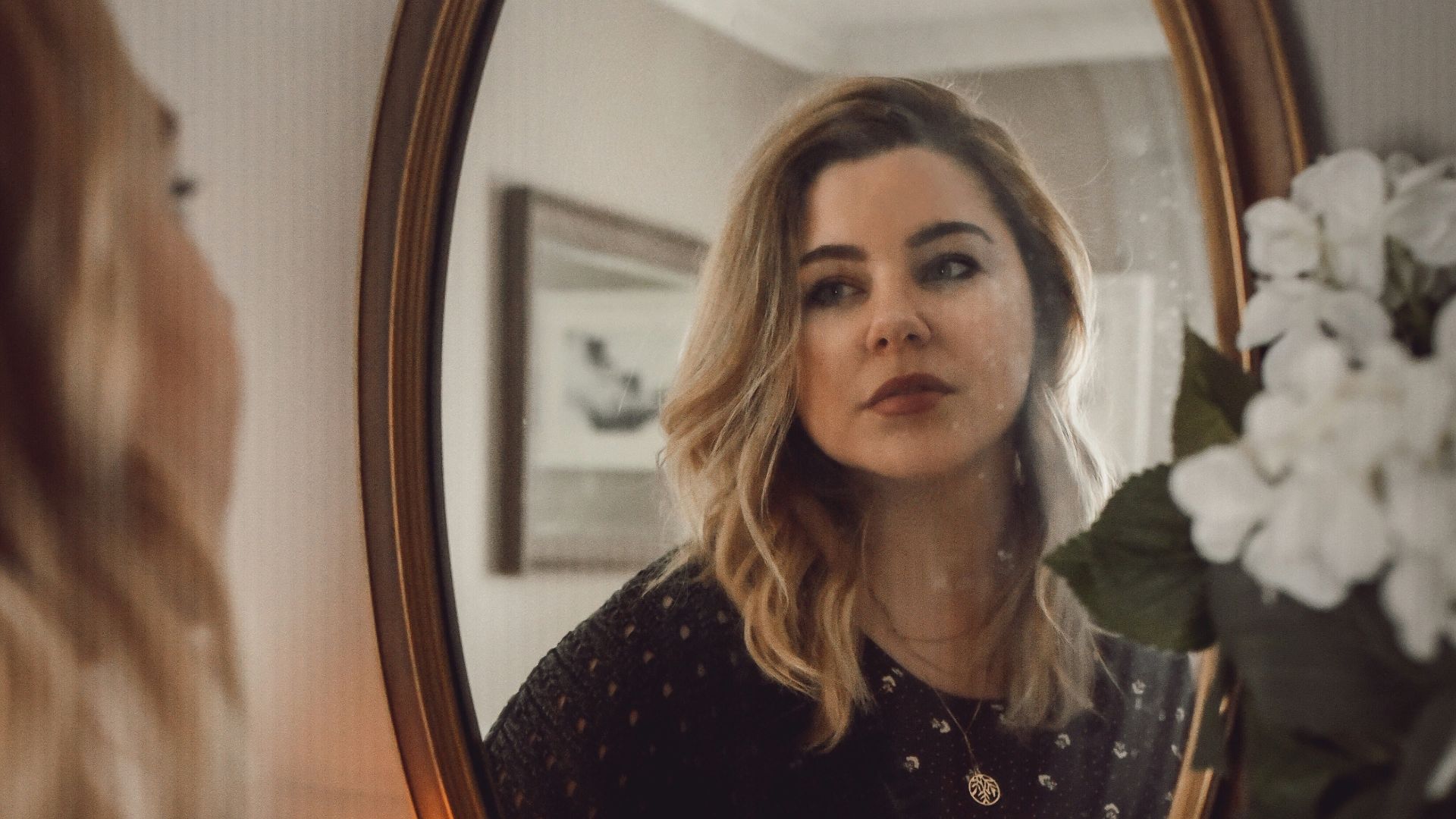 woman in black and white polka dot long sleeve shirt sitting on chair