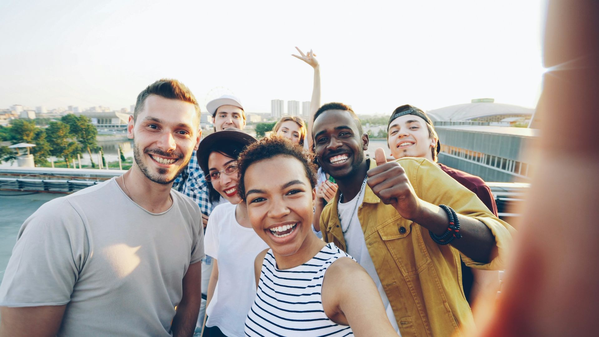 A diverse group of friends taking a selfie outdoors.