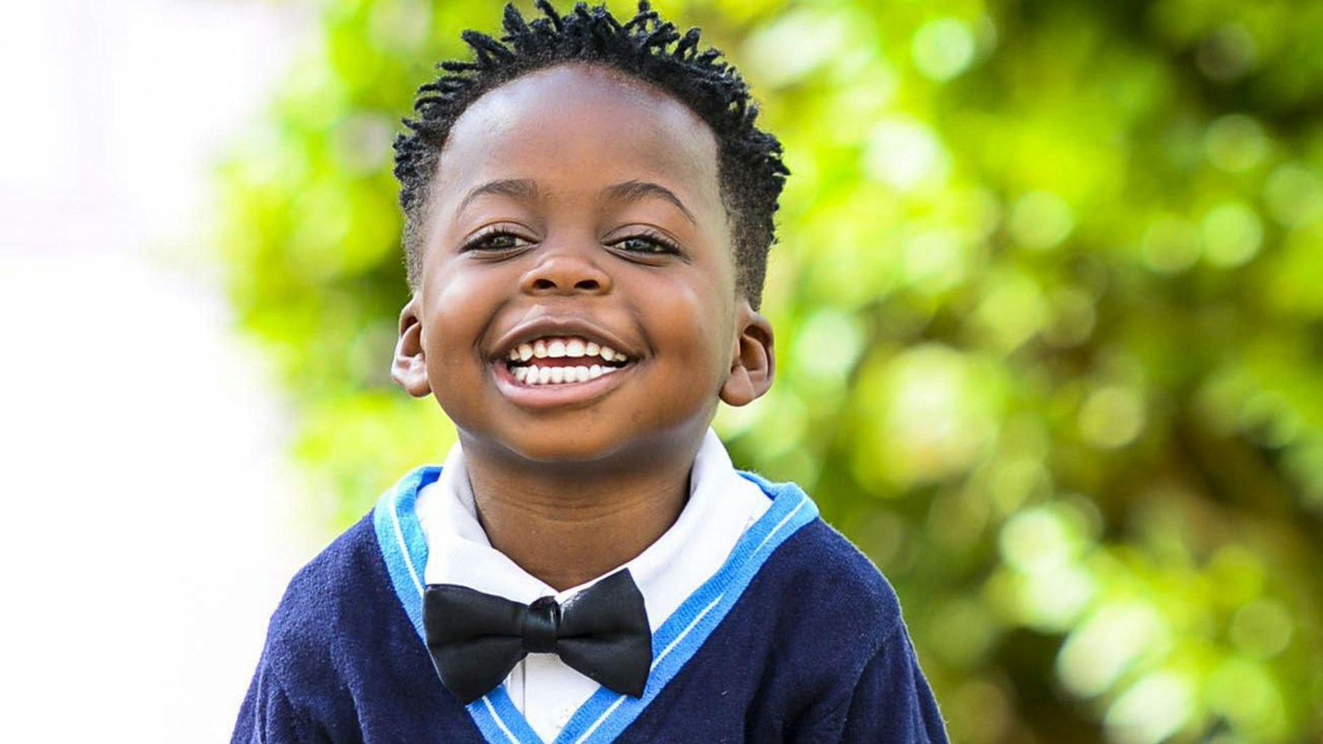 selective focus photo of boy standing on grey pavement