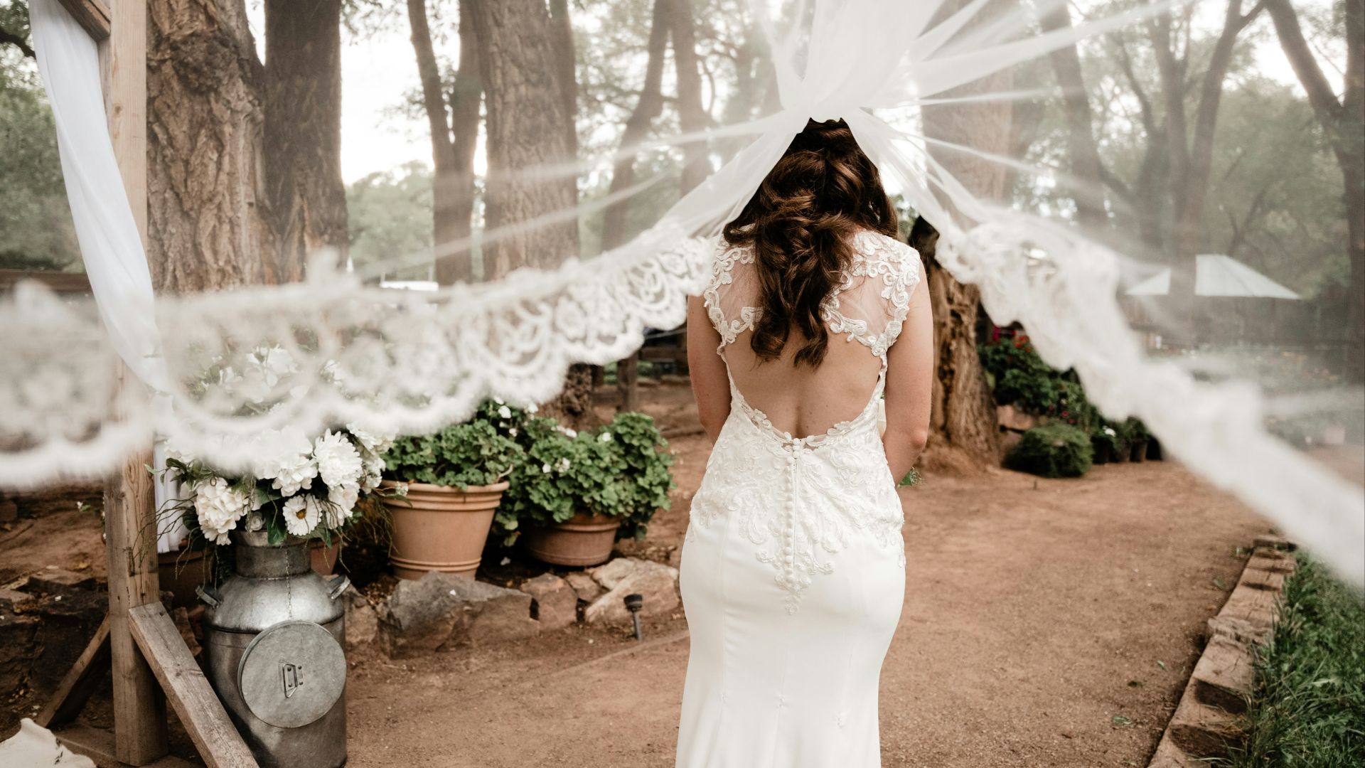a woman in a wedding dress standing under a veil