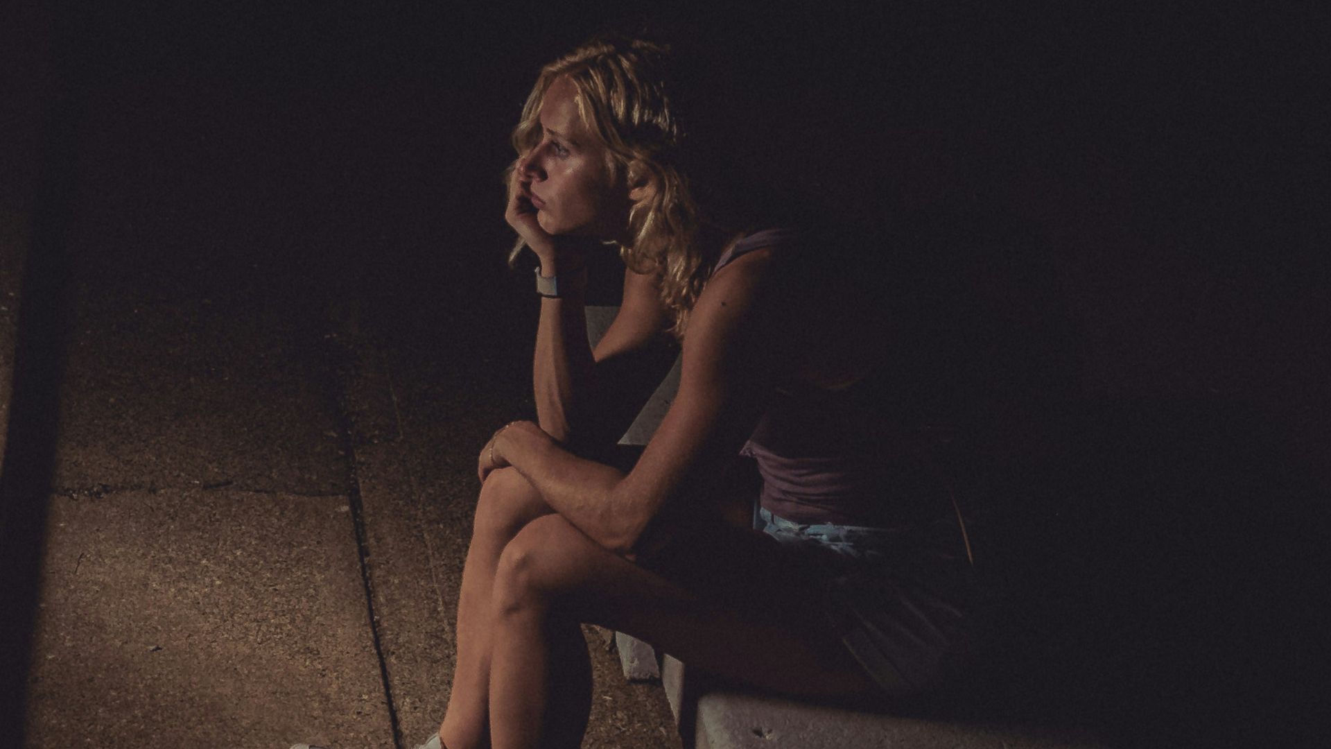 woman in black tank top sitting on concrete floor