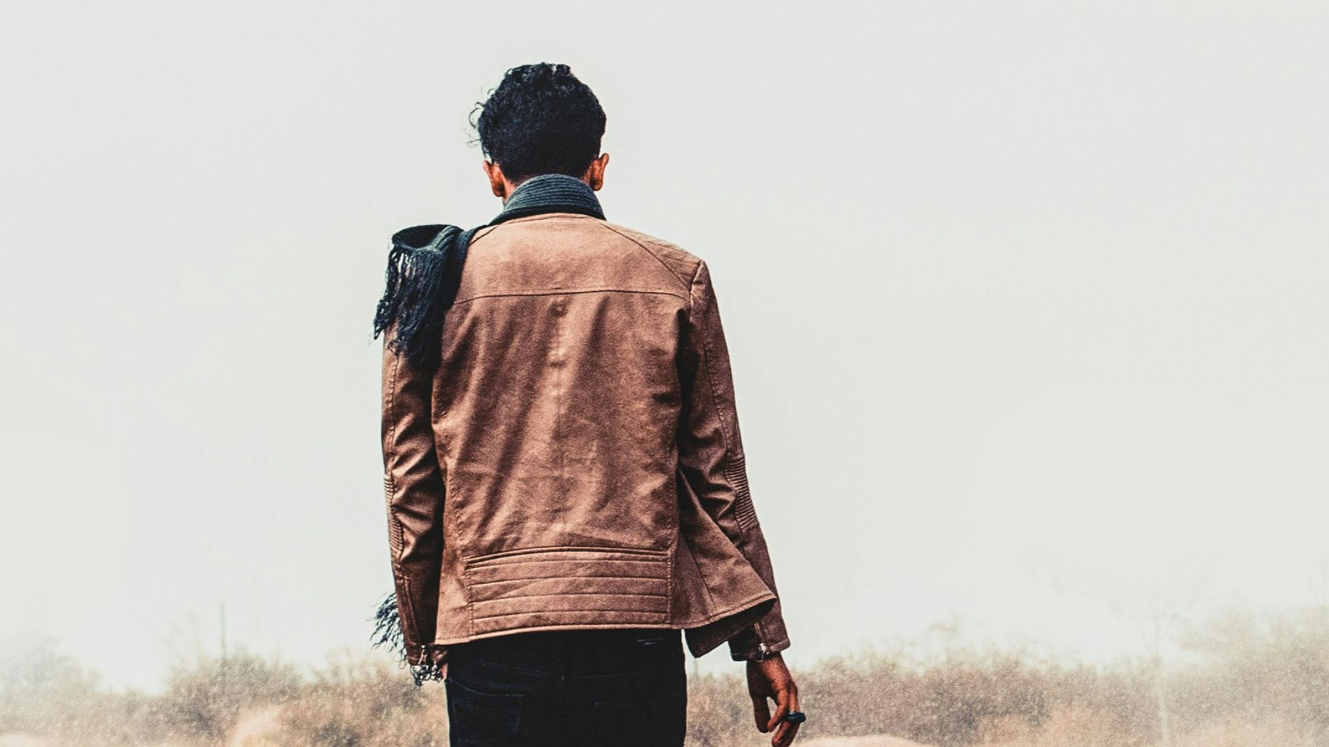 a man standing in a field with his back to the camera