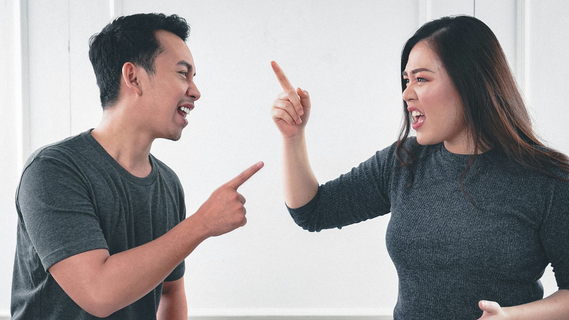 man in gray crew neck long sleeve shirt standing beside woman in black crew neck shirt