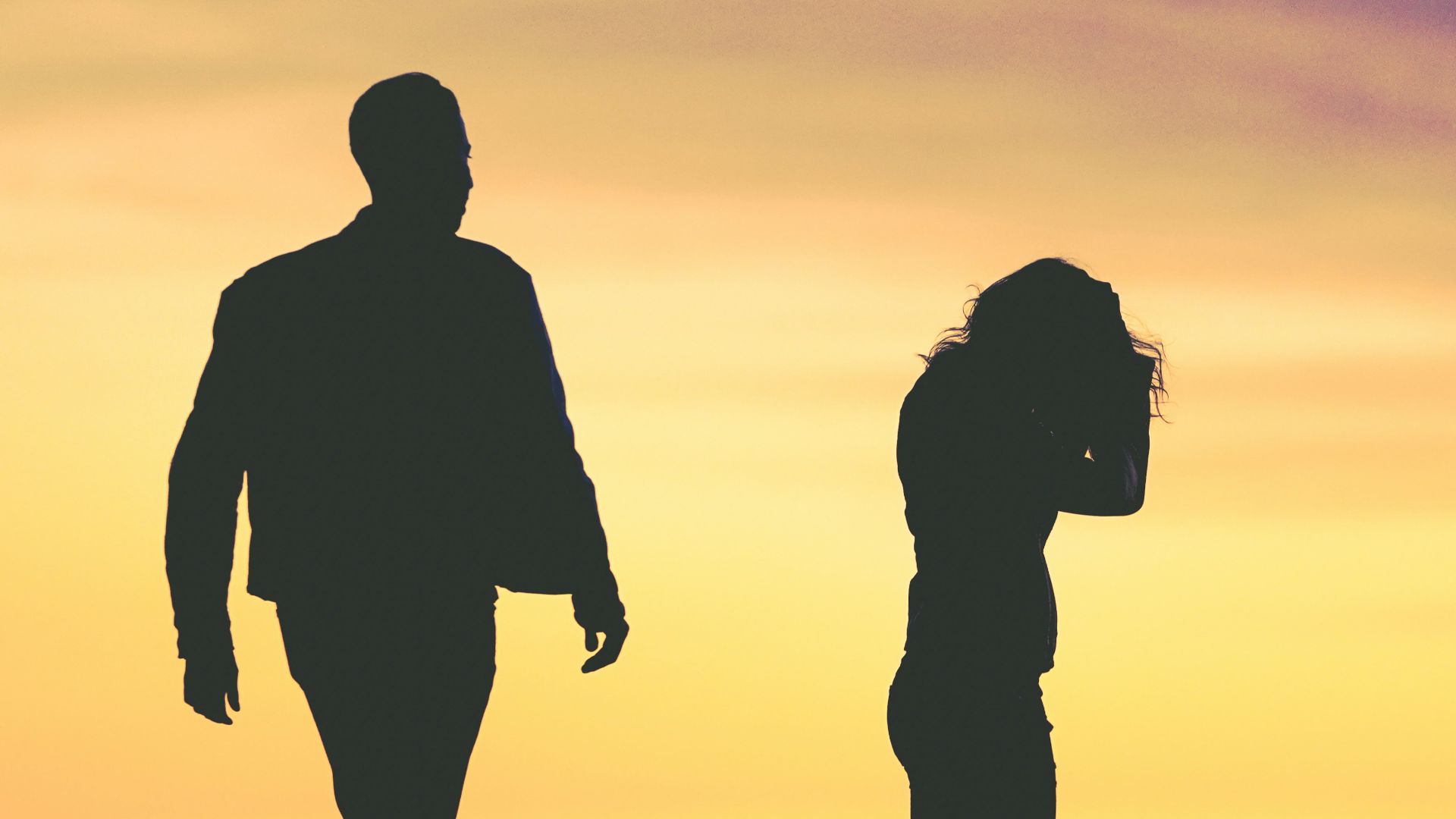 silhouette of man and woman under yellow sky