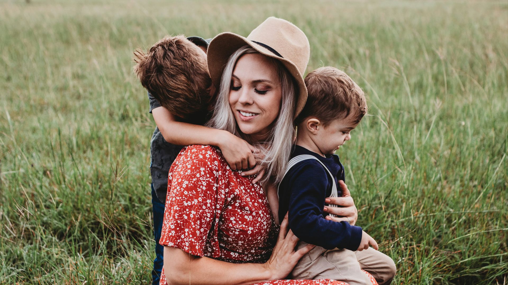 man and two children on grass field