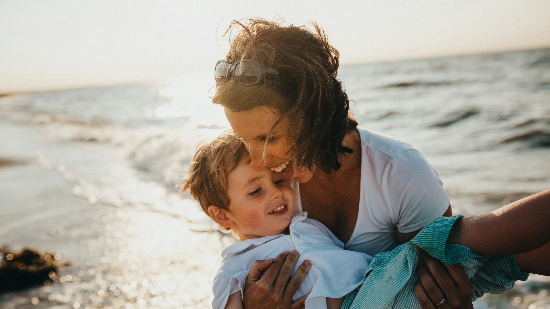 photo of mother and child beside body of water