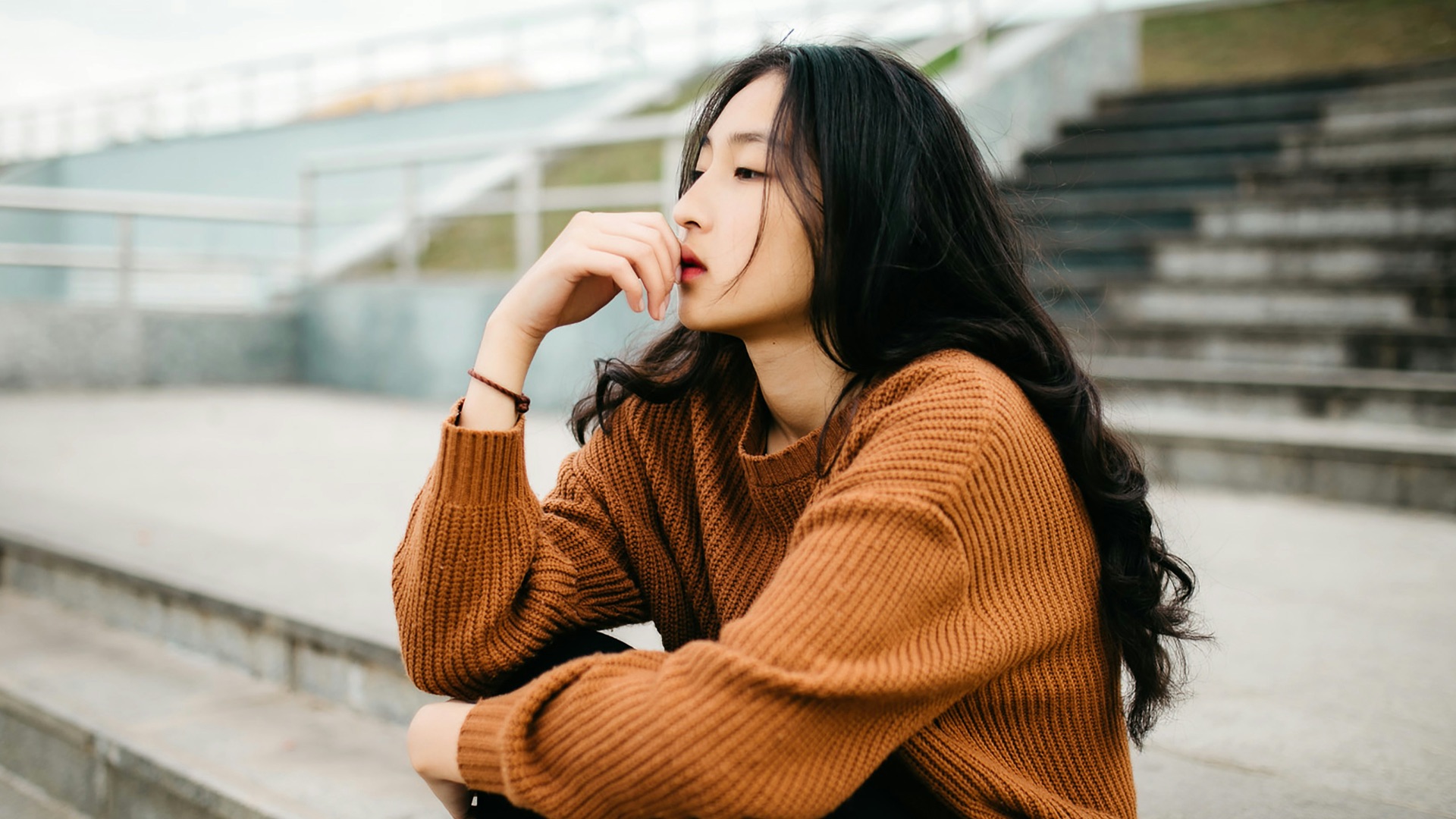 woman wearing brown sweater holding lips