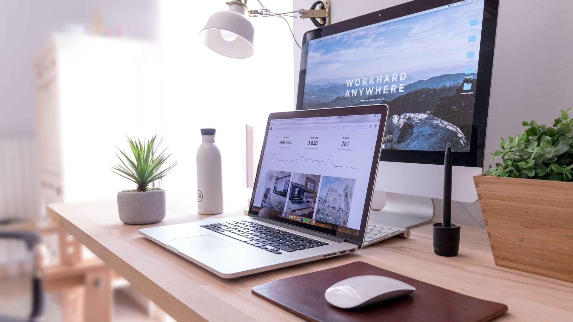 MacBook Pro on table beside white iMac and Magic Mouse