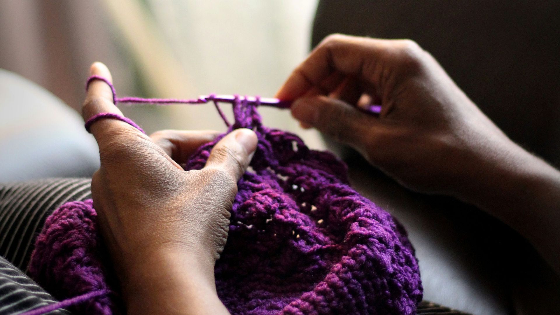 woman sewing purple textile
