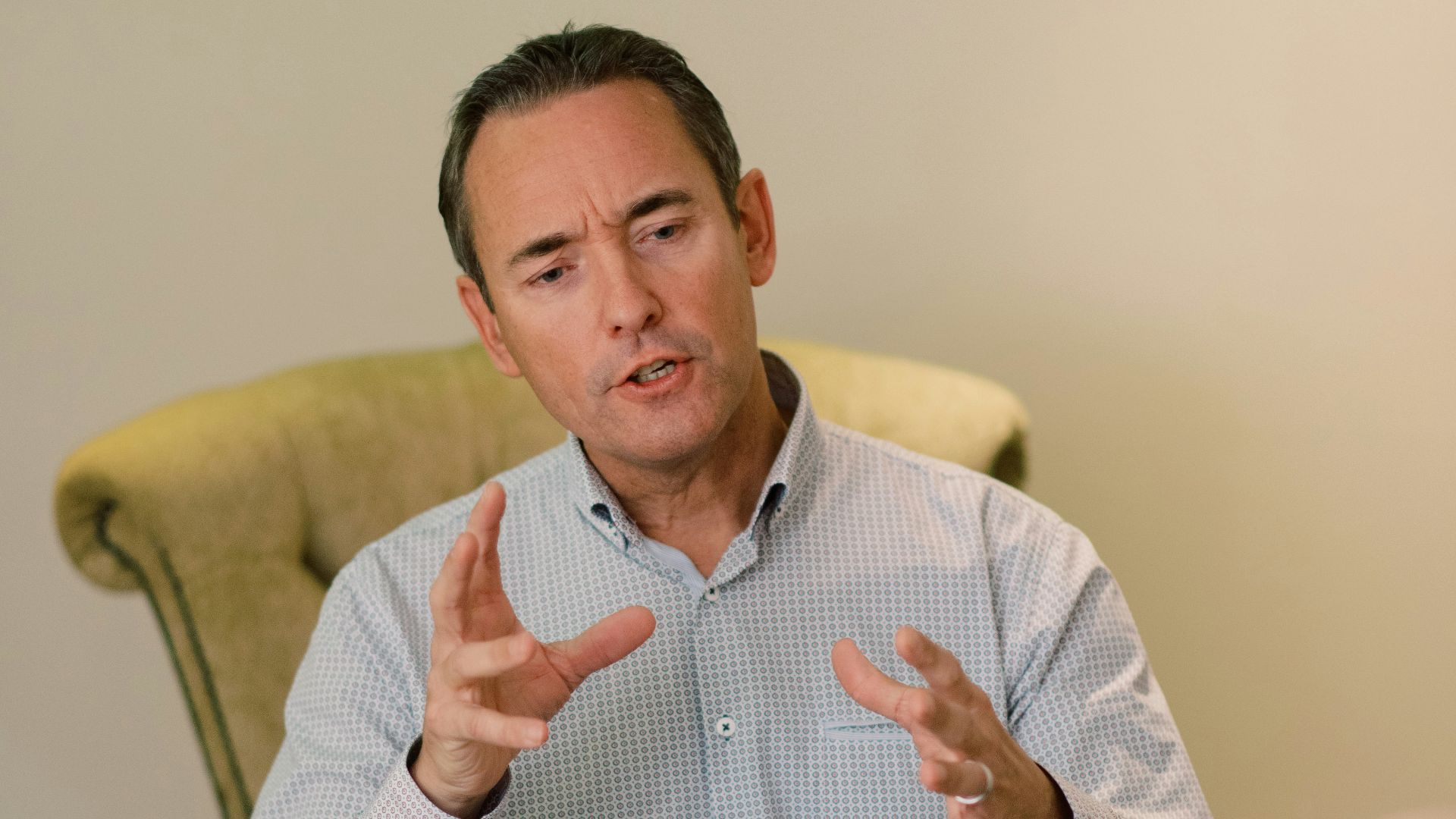 man in blue dress shirt sitting on yellow chair