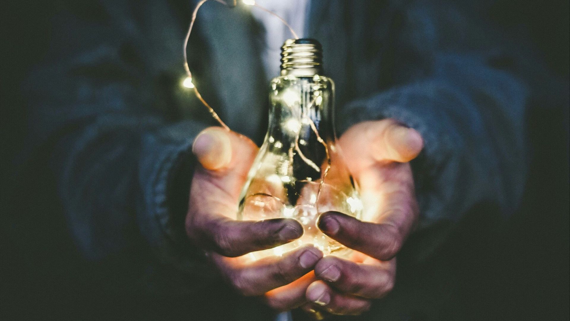 man holding incandescent bulb