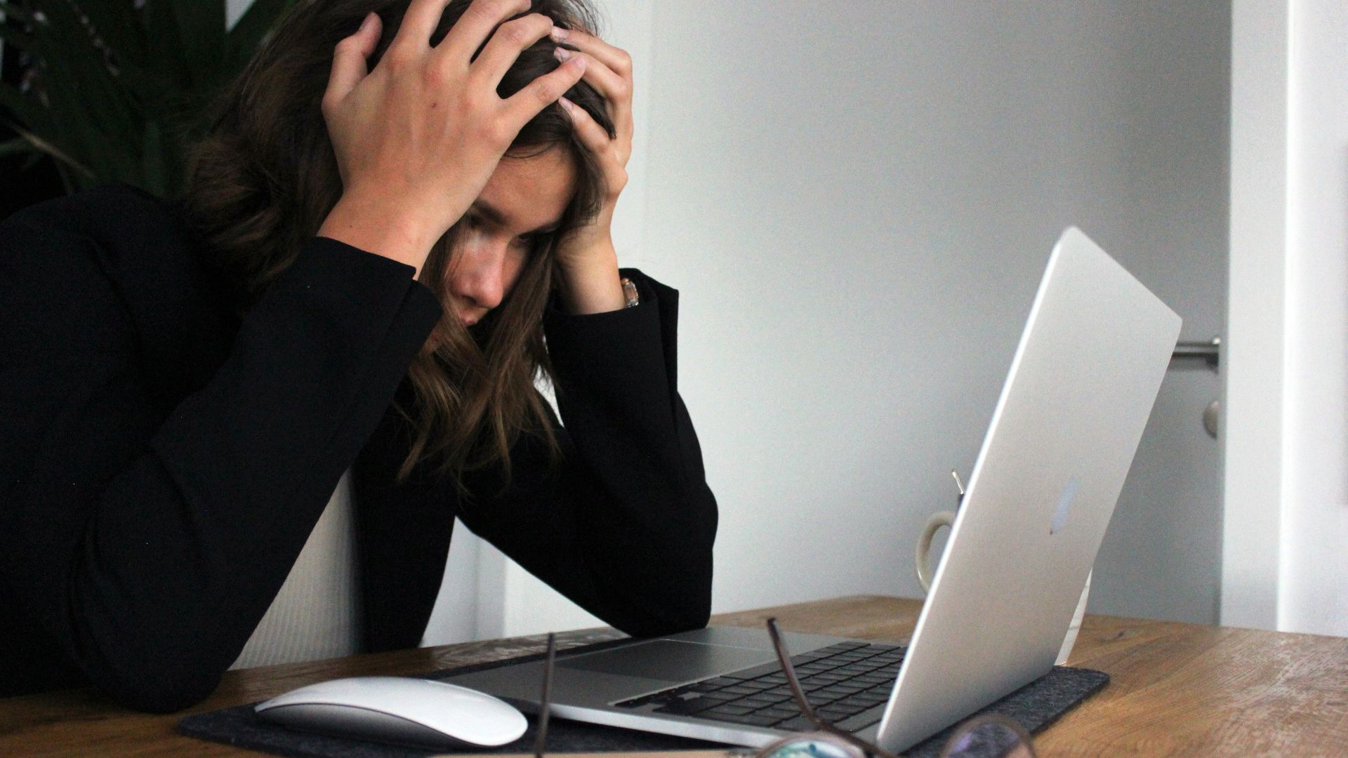 a woman sitting in front of a laptop computer