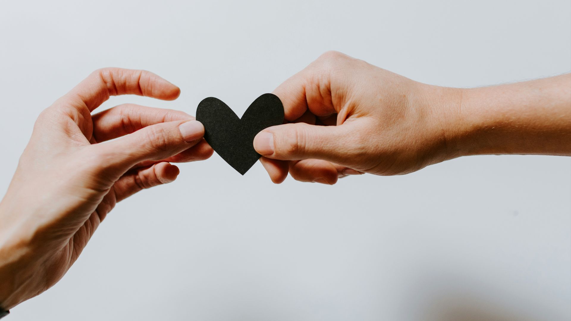 two person holding papercut heart