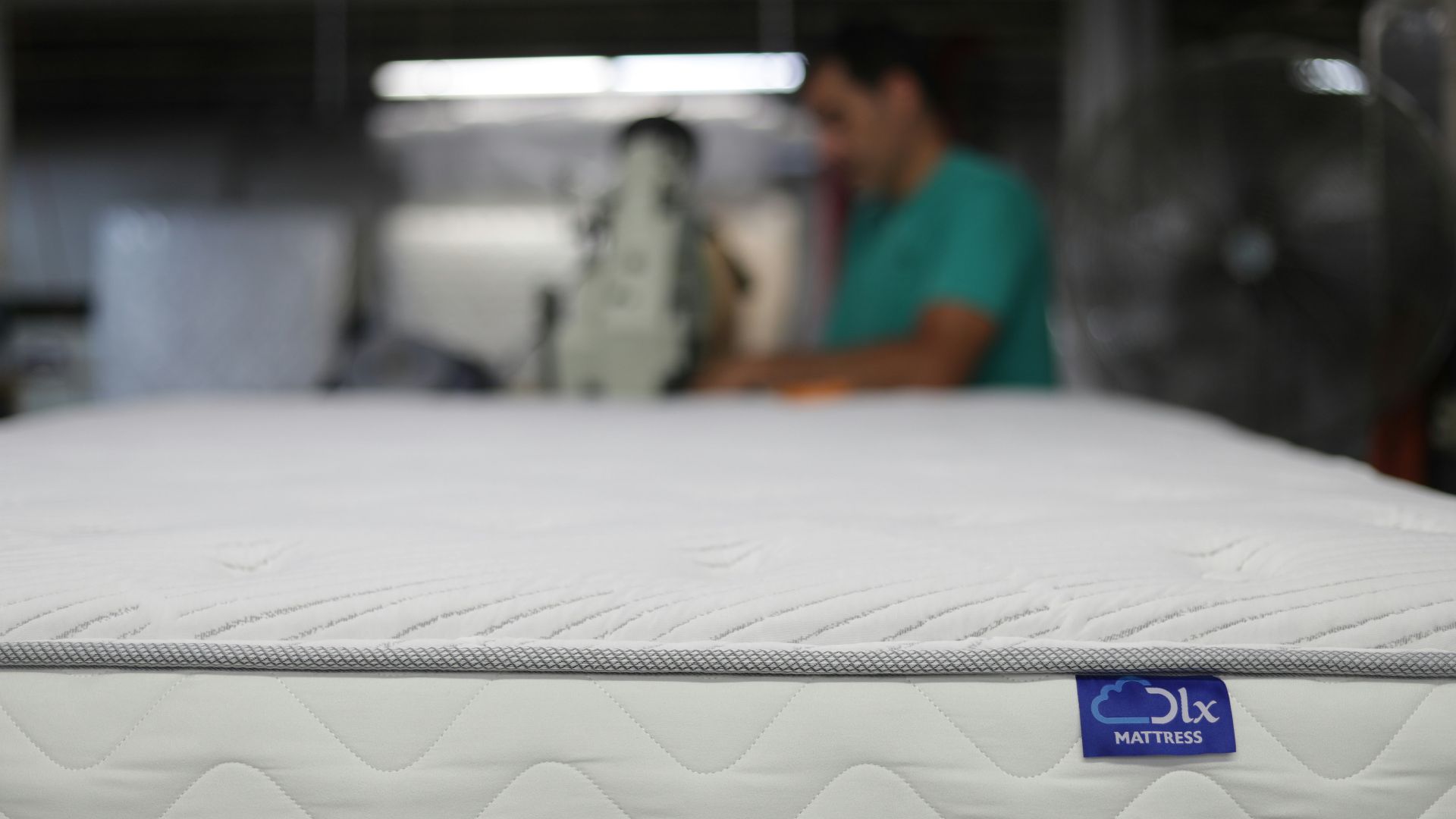a man is working on a mattress in a warehouse