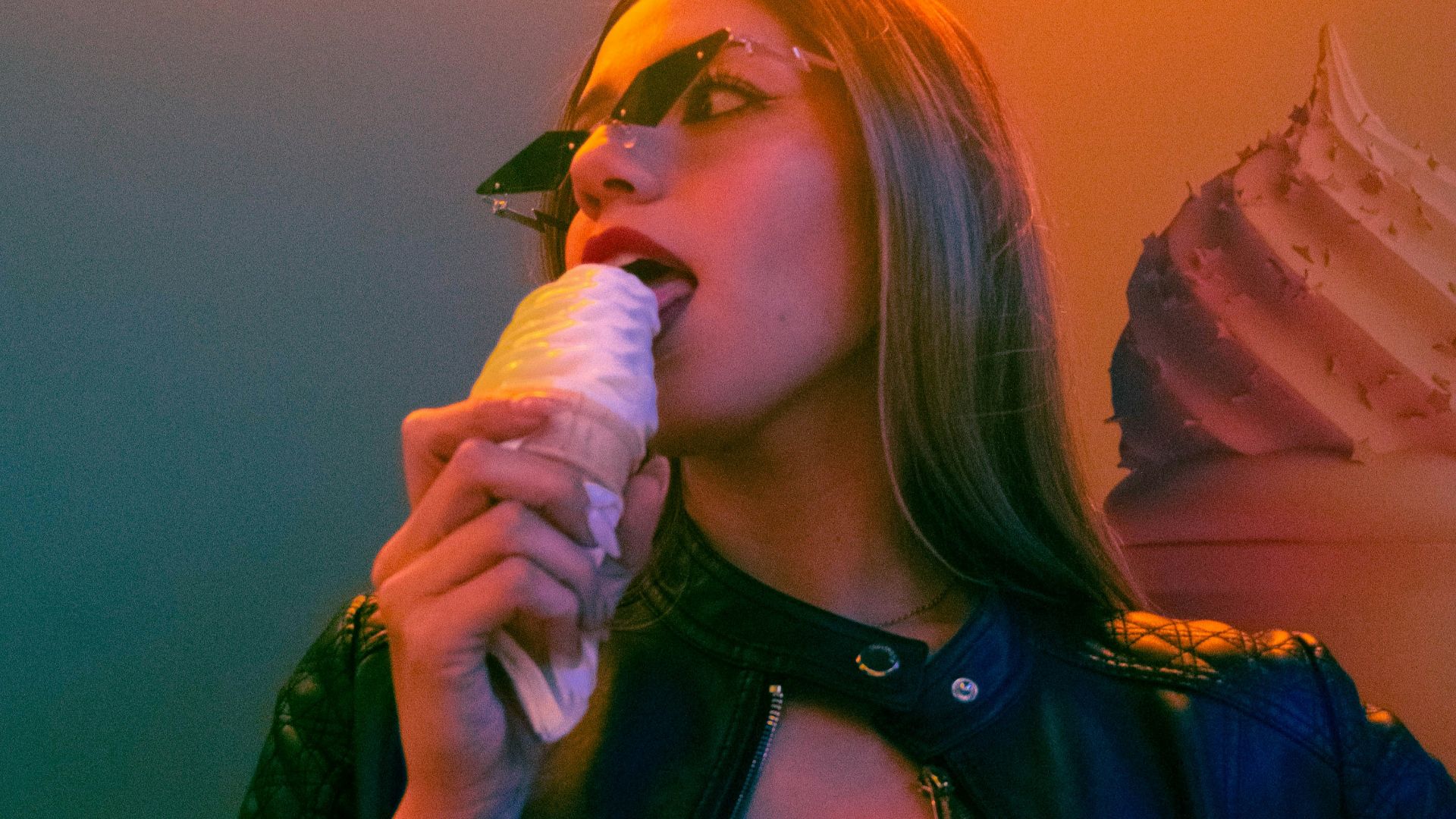 Woman eating ice cream cone under neon sign