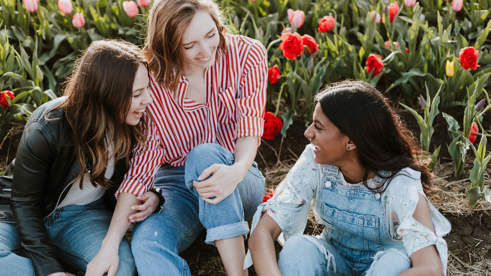 three woman sitting near the flower