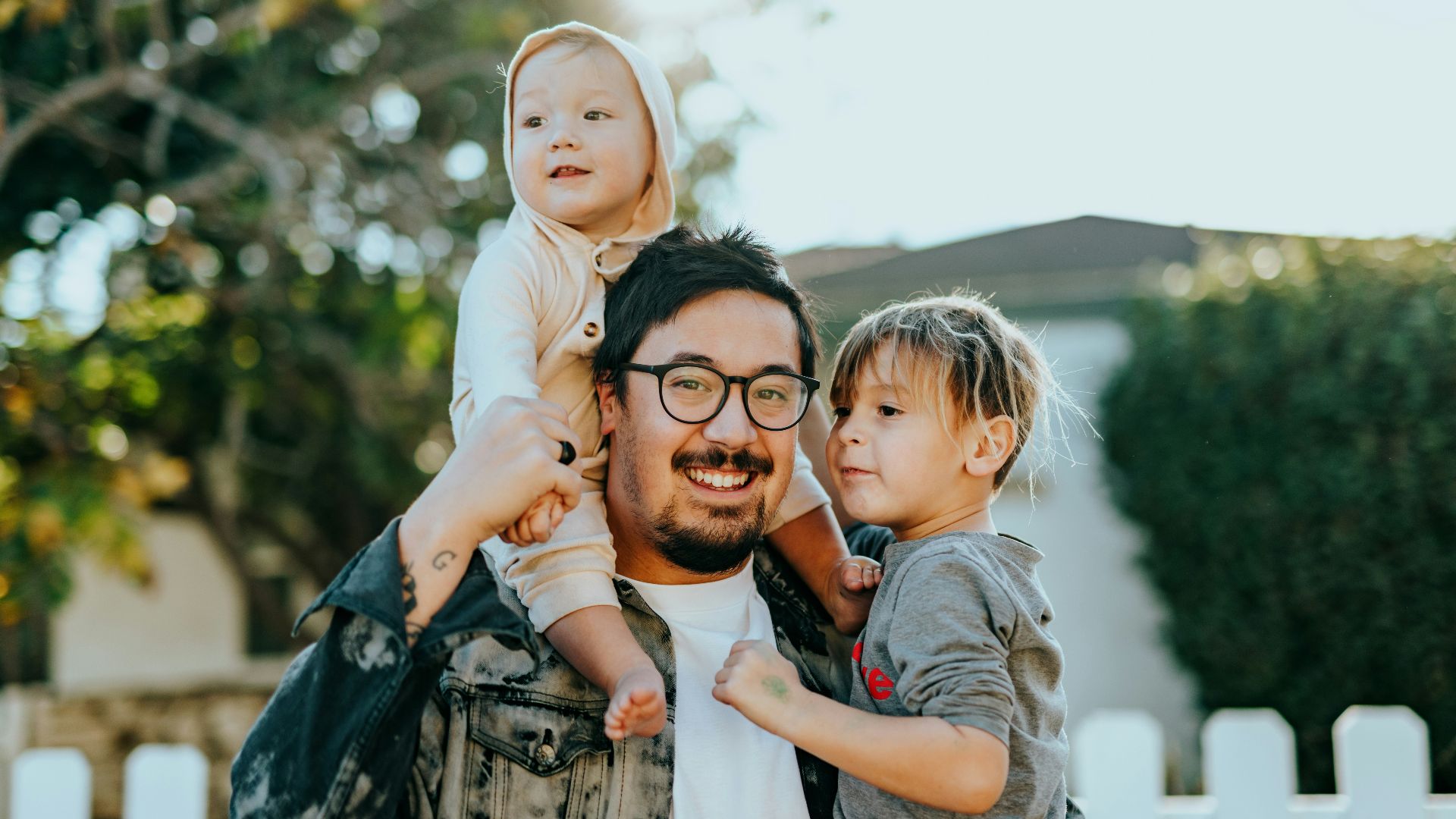man in white shirt carrying girl in gray shirt