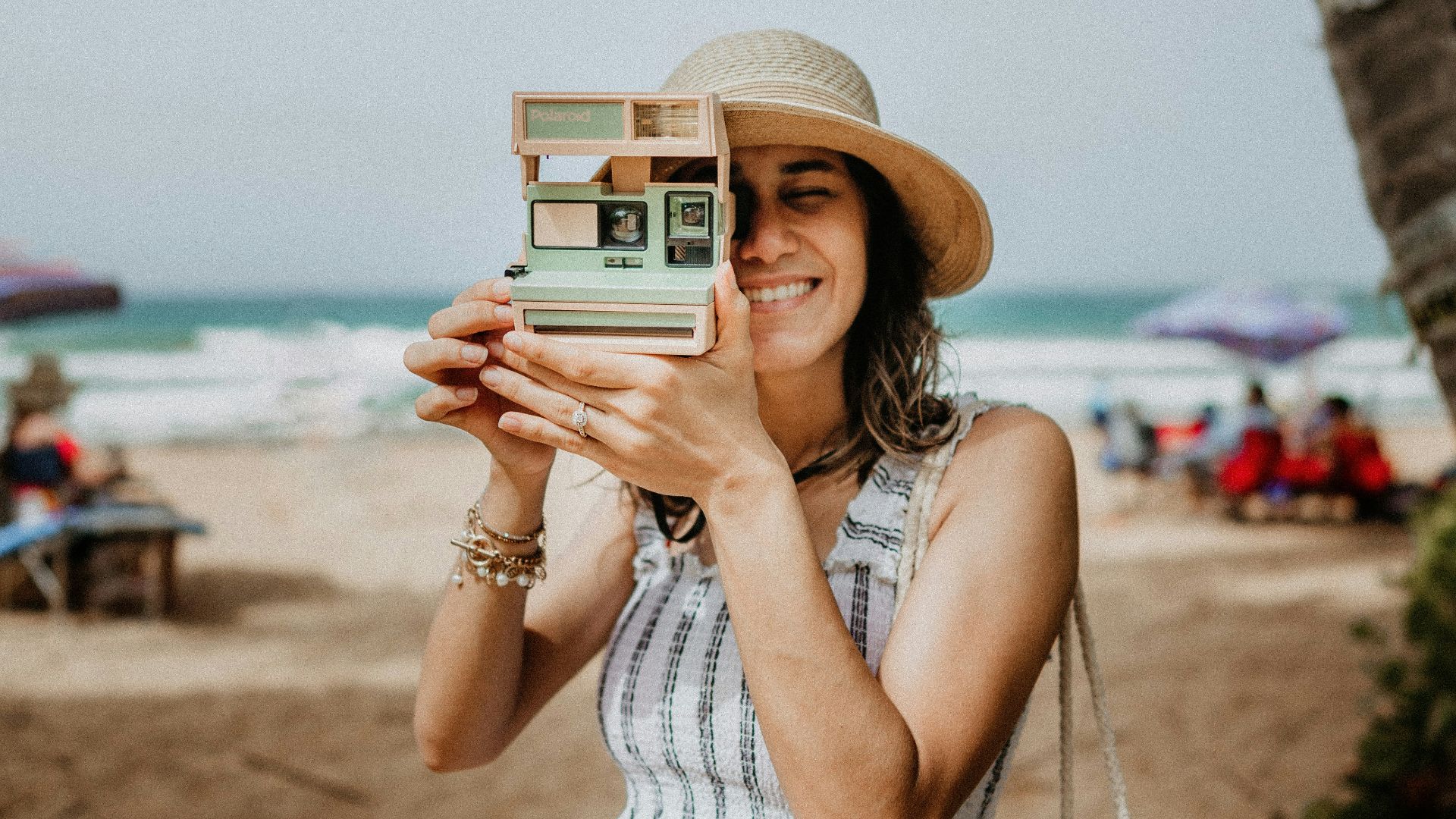 woman in white and blue stripe dress holding white and black camera