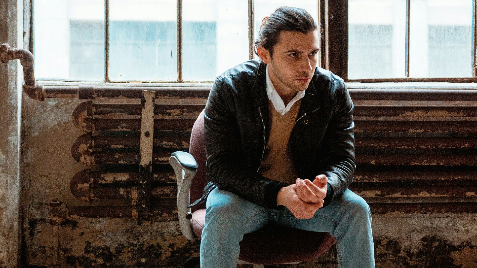man in black jacket sitting on chair