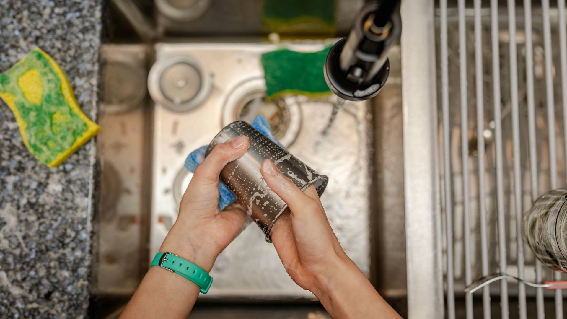 A person is cleaning a sink with a rag