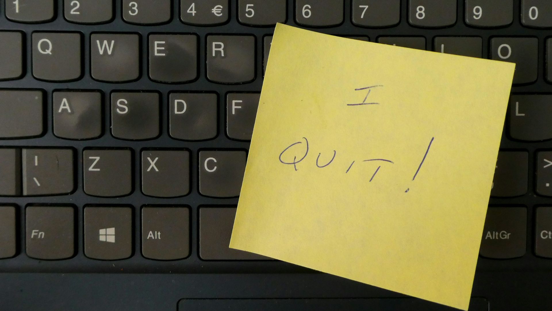 a yellow notepad on a keyboard