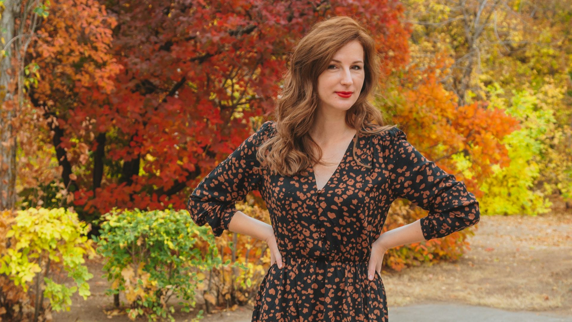 woman in black and white floral dress standing on gray concrete floor