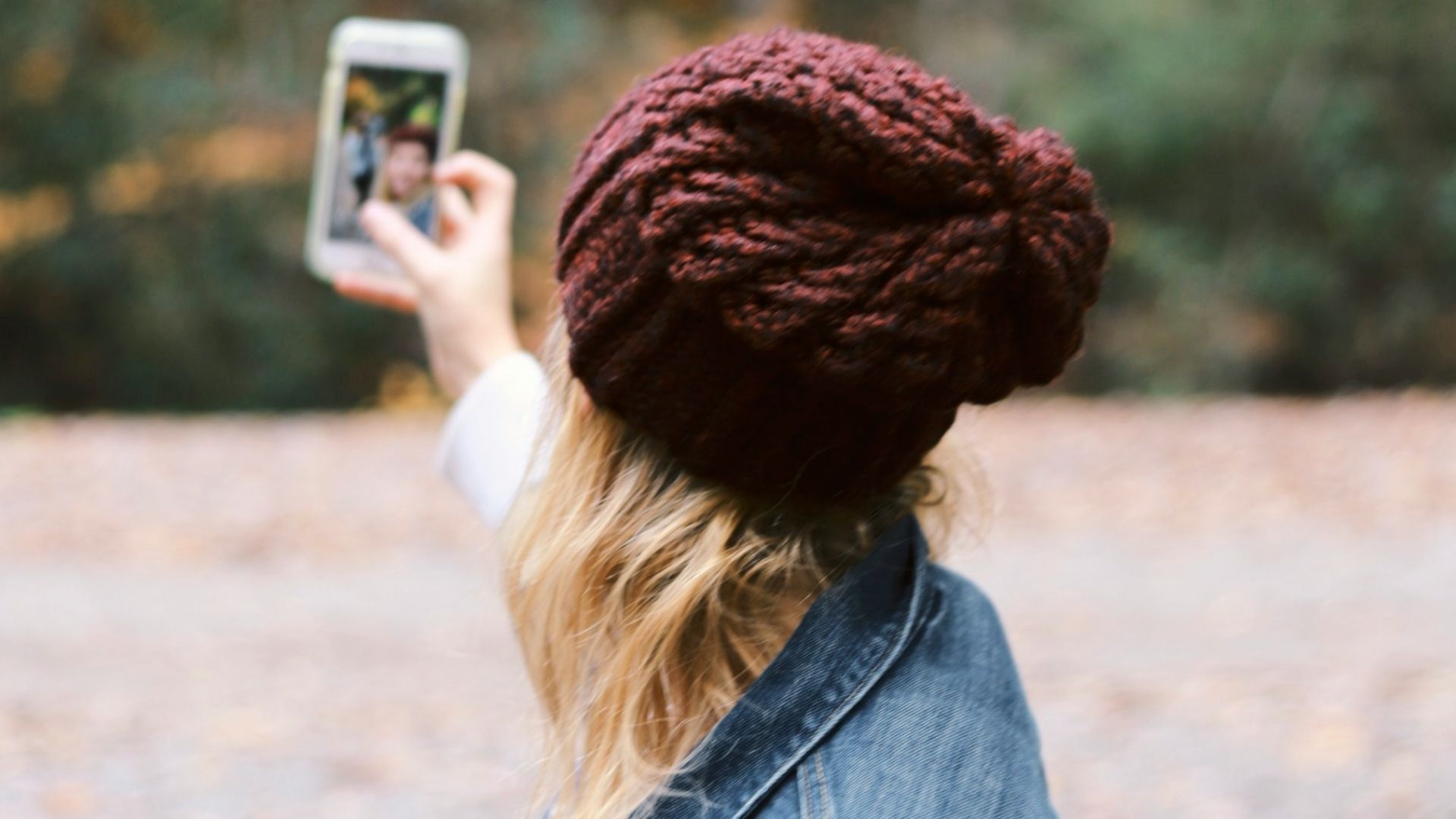 woman taking selfie near trees