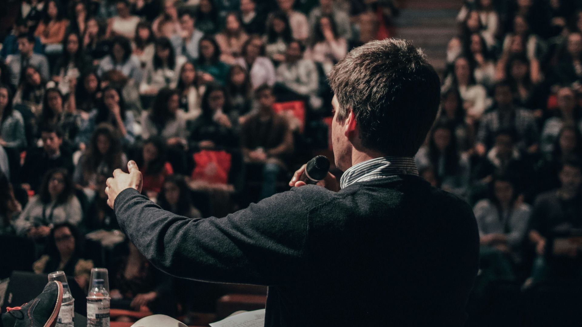man speaking in front of crowd