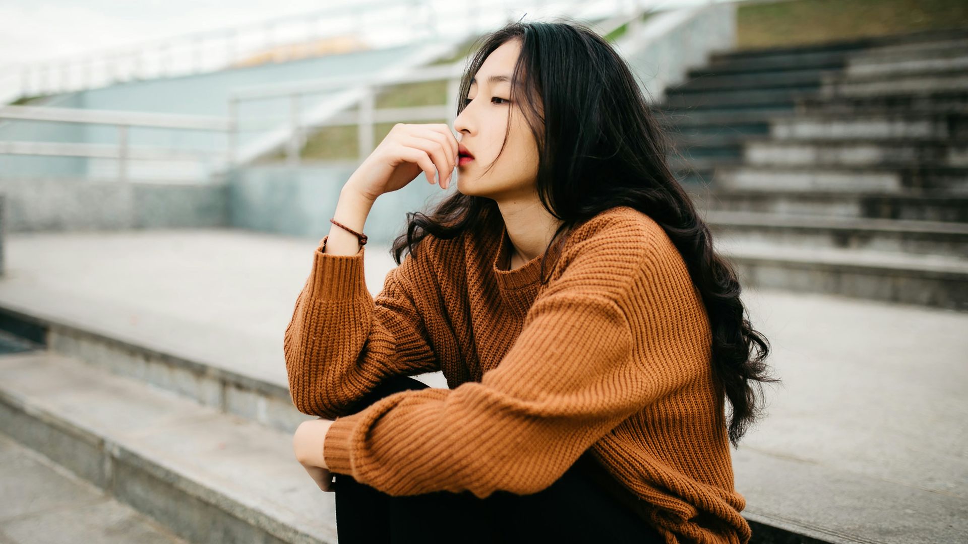 woman wearing brown sweater holding lips