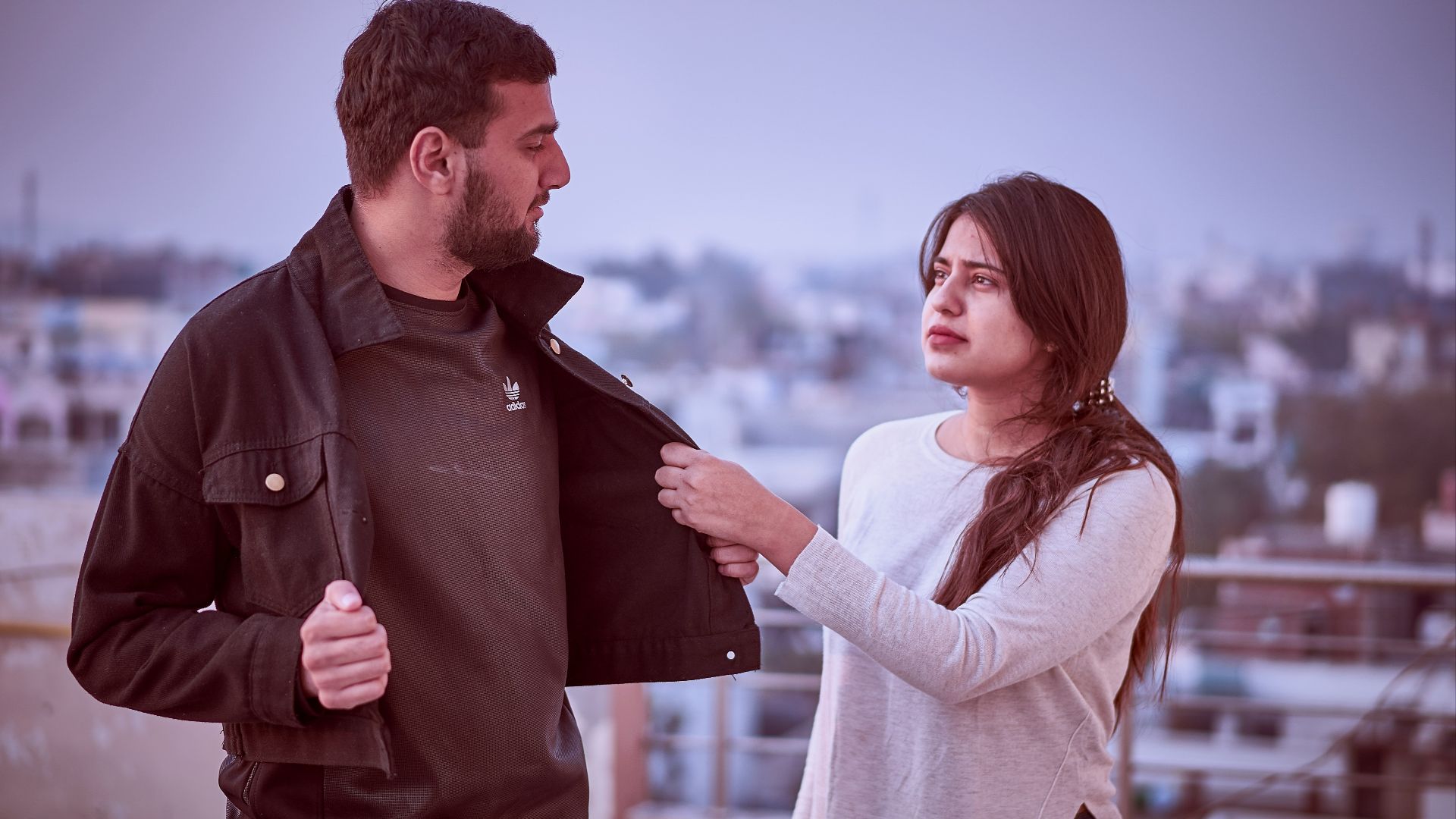 man in brown jacket and woman in white sweater standing on brown wooden dock during daytime