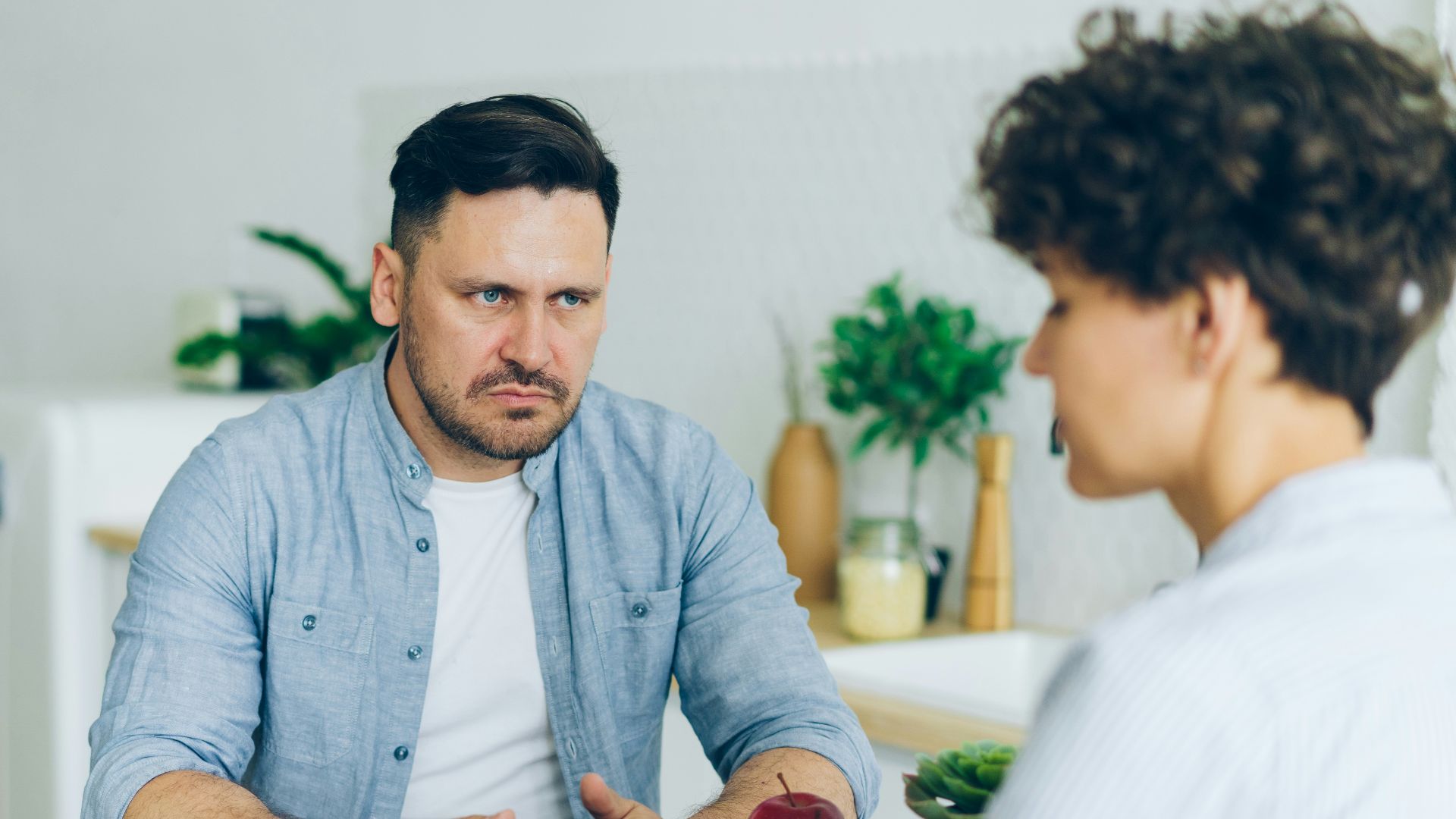 a man sitting at a table talking to a woman
